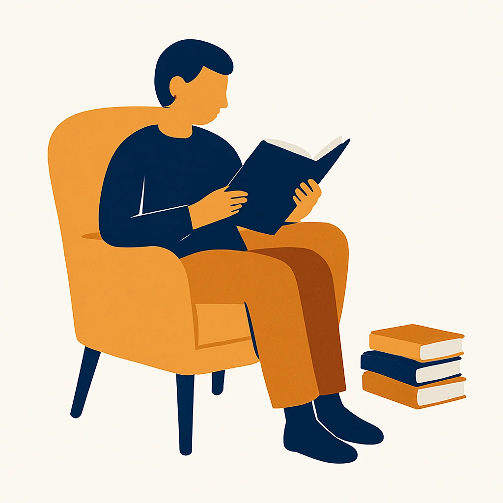 A person reading in an armchair next to a stack of books